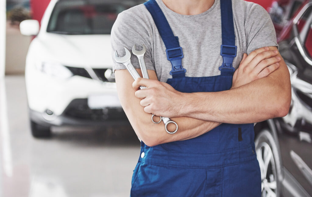 Hand of car mechanic with wrench. Auto repair garage.